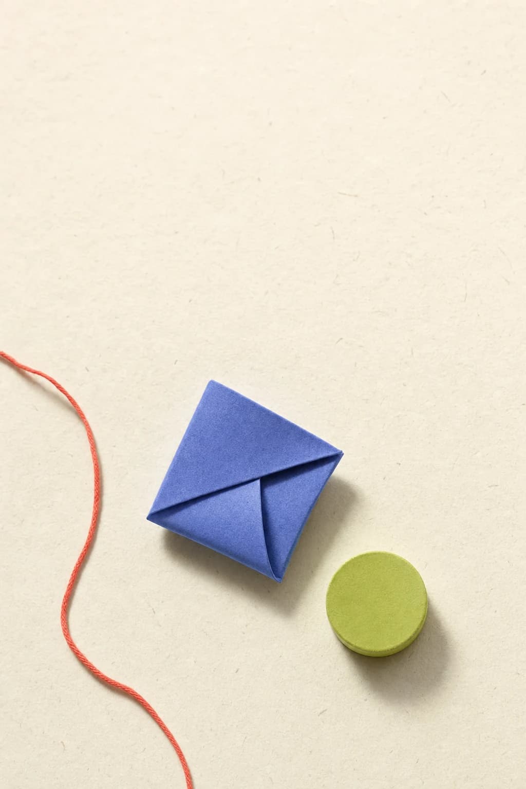 A periwinkle paper form and lime token arranged on warm paper